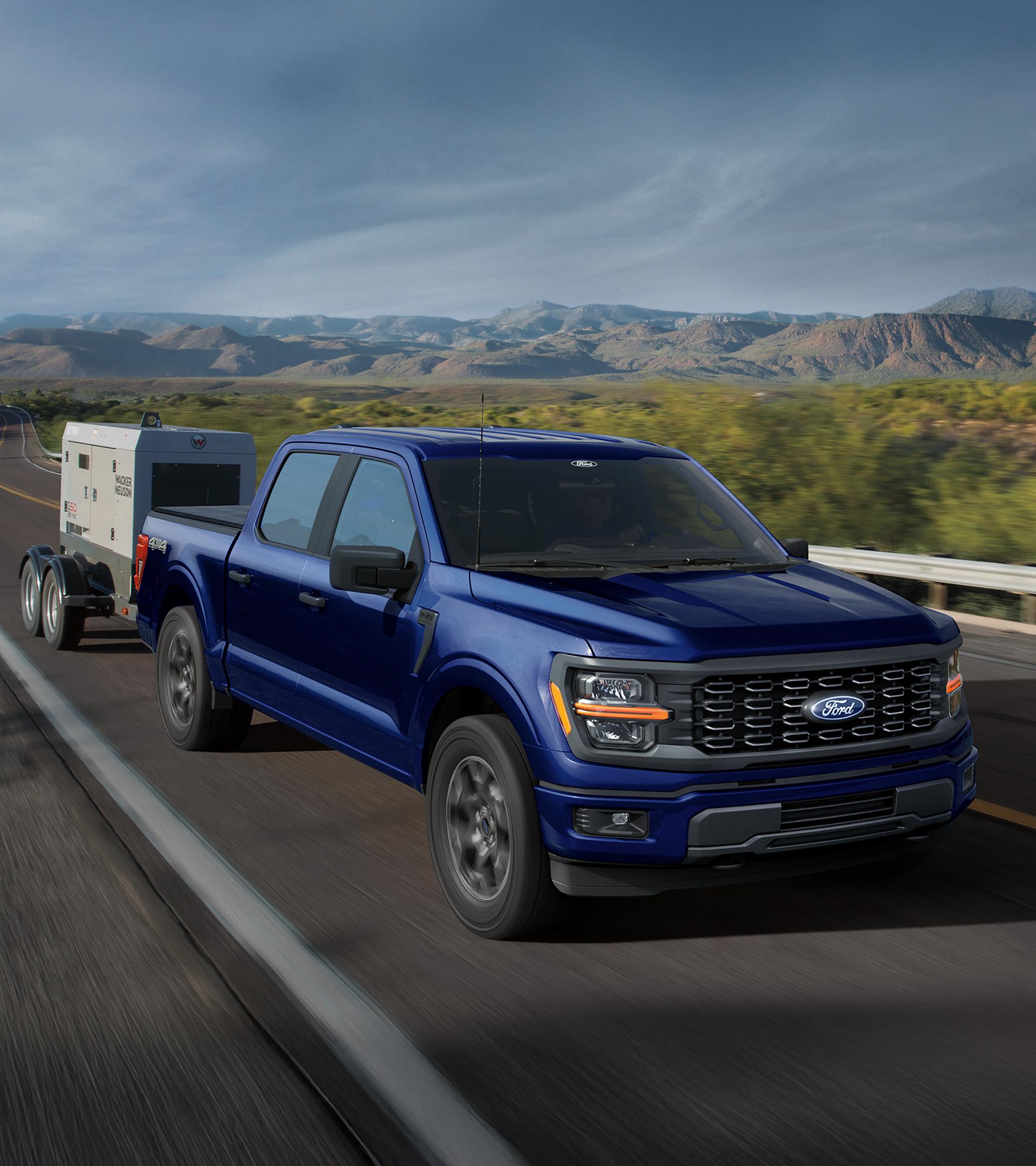 Blue 2026 Ford F-150 towing equipment on the highway