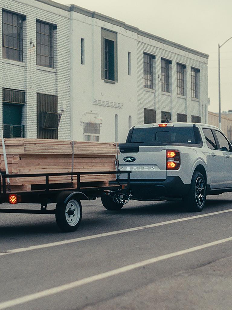 Ford Maverick towing a trailer with lumber