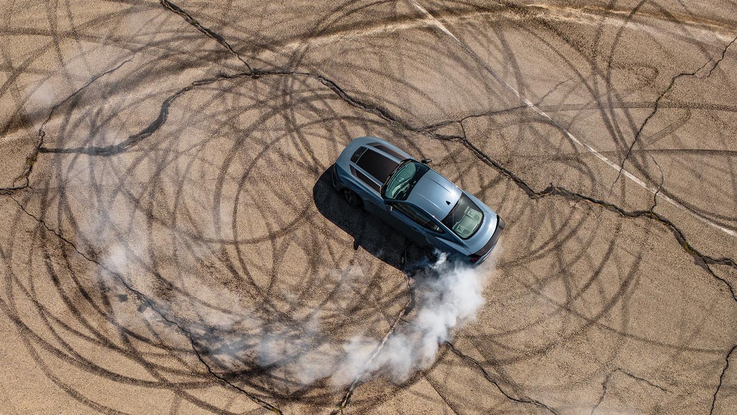 2026 Ford Mustang® Dark Horse™ coupe in Vapor Blue Metallic with a driver performing burnouts on a closed course