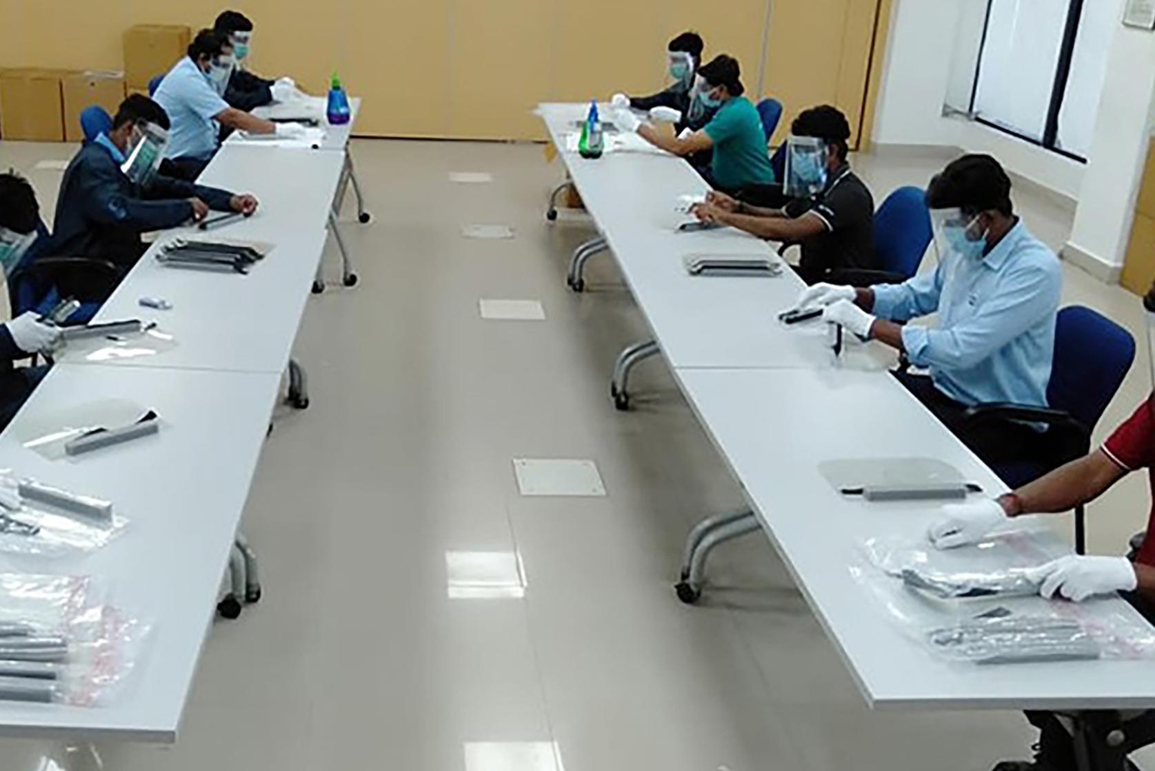 A group of Ford employees inspect and sort face shields