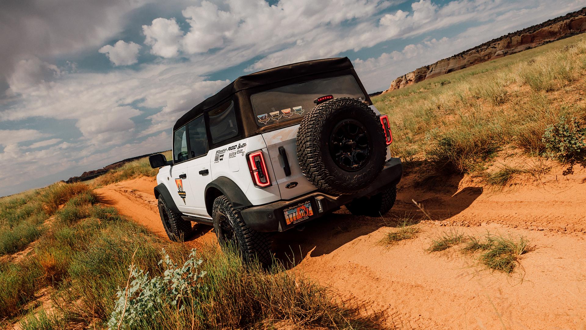 A 2026 Ford Bronco® SUV being driven on a dirt path in Moab, Utah