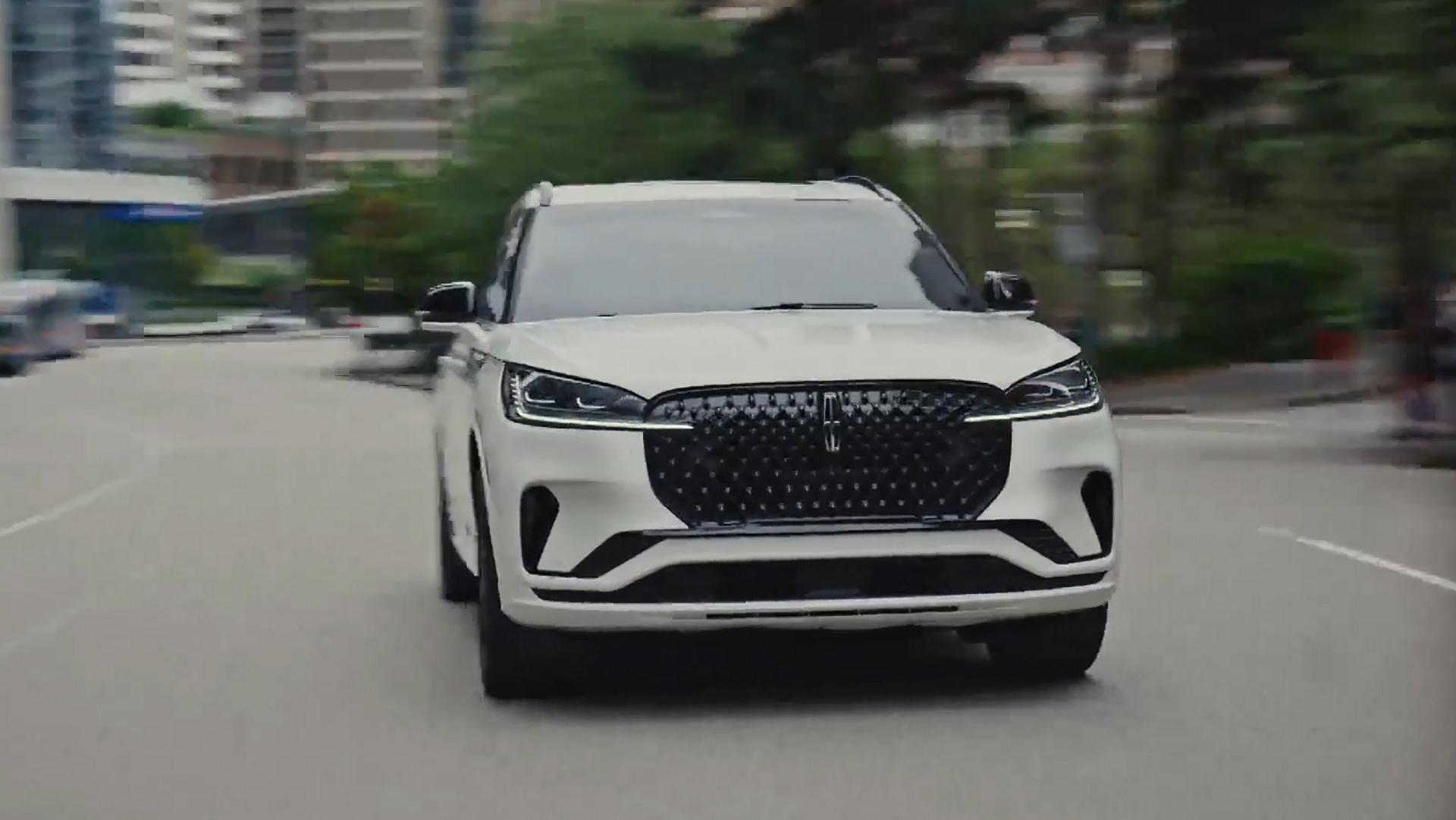 A 2026 Lincoln Aviator® SUV is being driven on a highway near a city