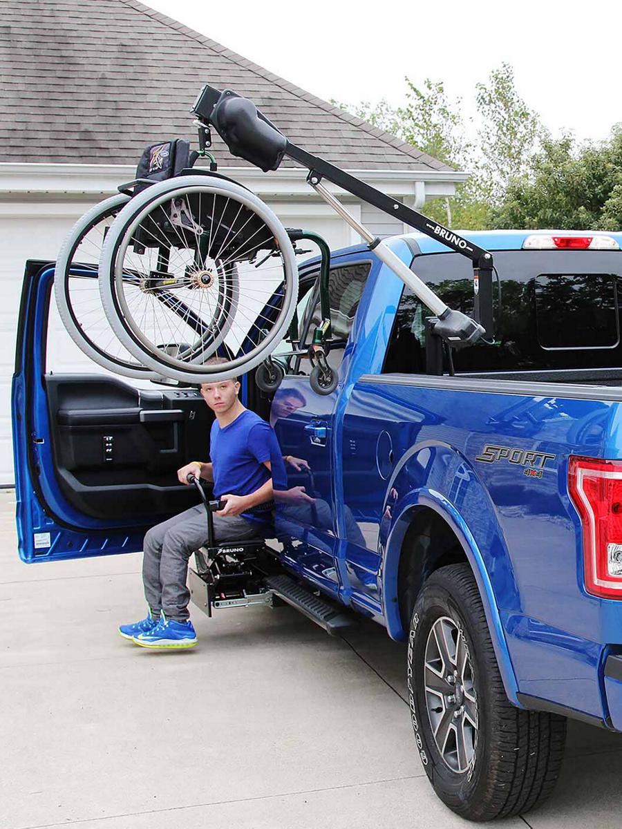 Un F-150 bleu avec un palan de fauteuil roulant dans la caisse