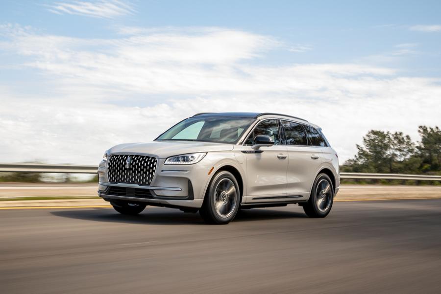 The 2025 Corsair® Grand Touring SUV on a paved road overlooking a city skyline in the background