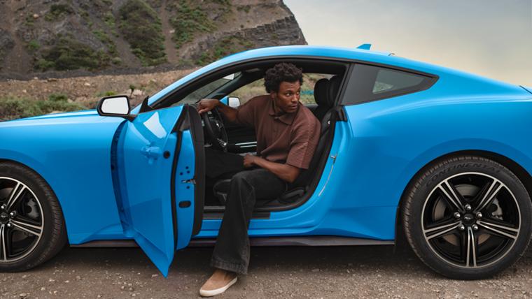 Person exiting a 2025 Ford Mustang® coupe parked in the desert