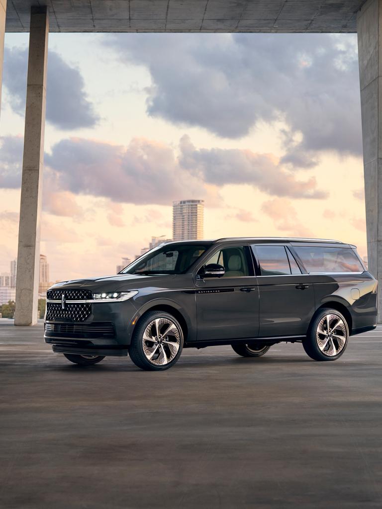 Una SUV Lincoln Navigator® 2026 con distancia entre ejes larga estacionada frente a un paisaje urbano