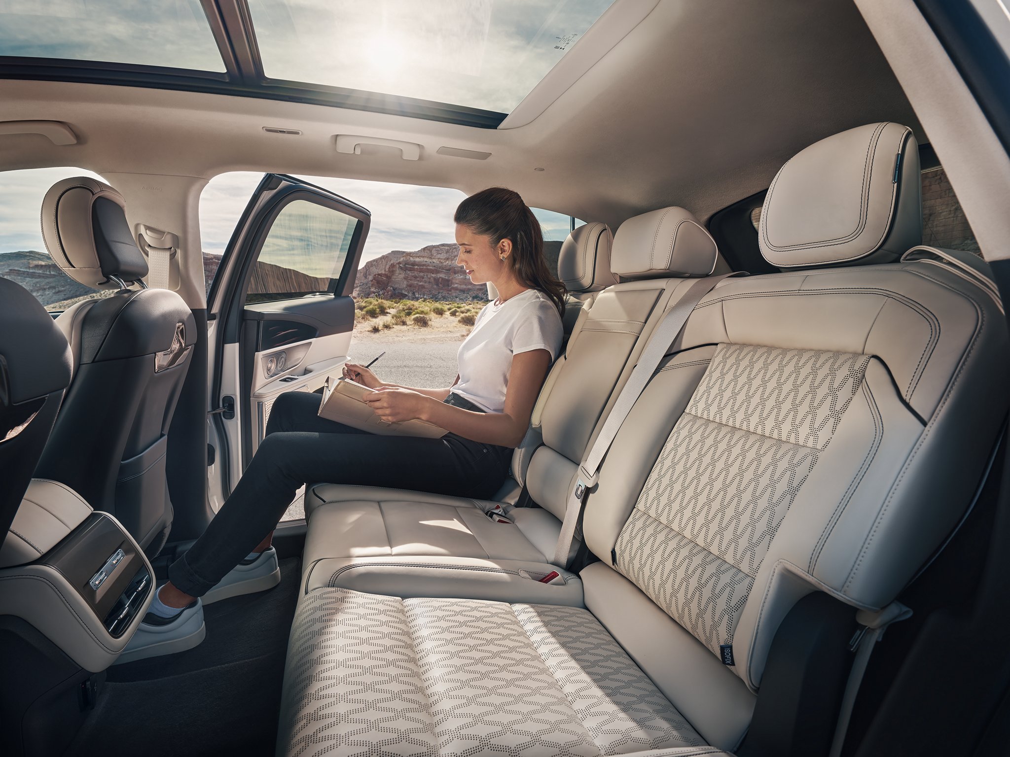 A person takes a relaxing moment in the second row of a 2025 Lincoln Black Label Nautilus SUV