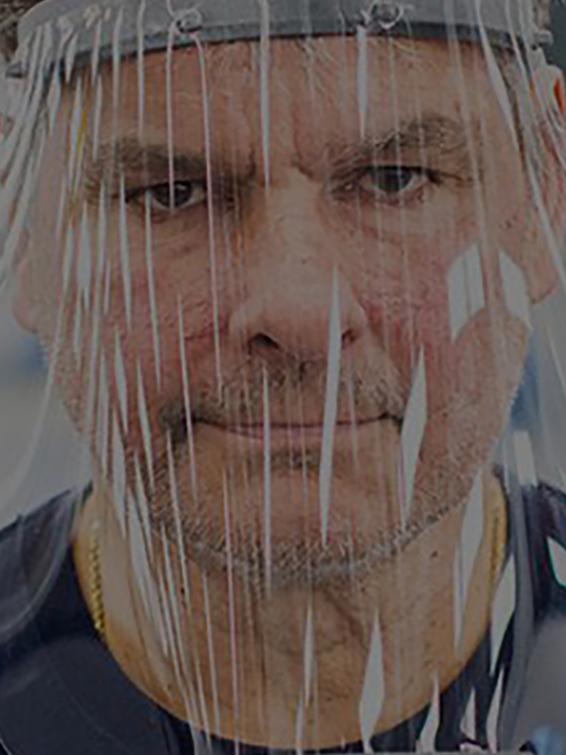 Male employee in blue shirt wearing face shield