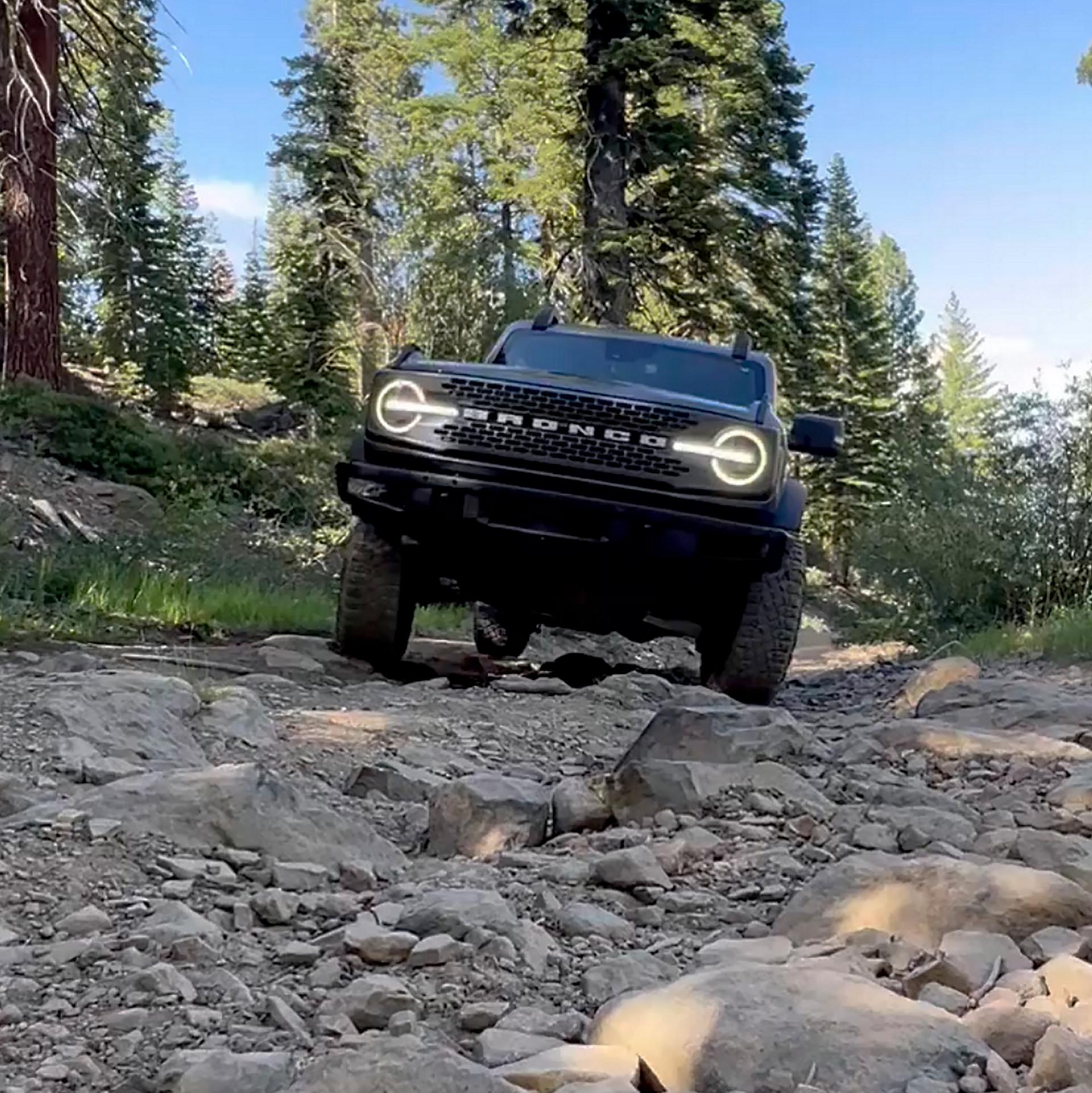 A 2026 Ford Bronco® SUV being driven over rocks and boulders in a dry riverbed
