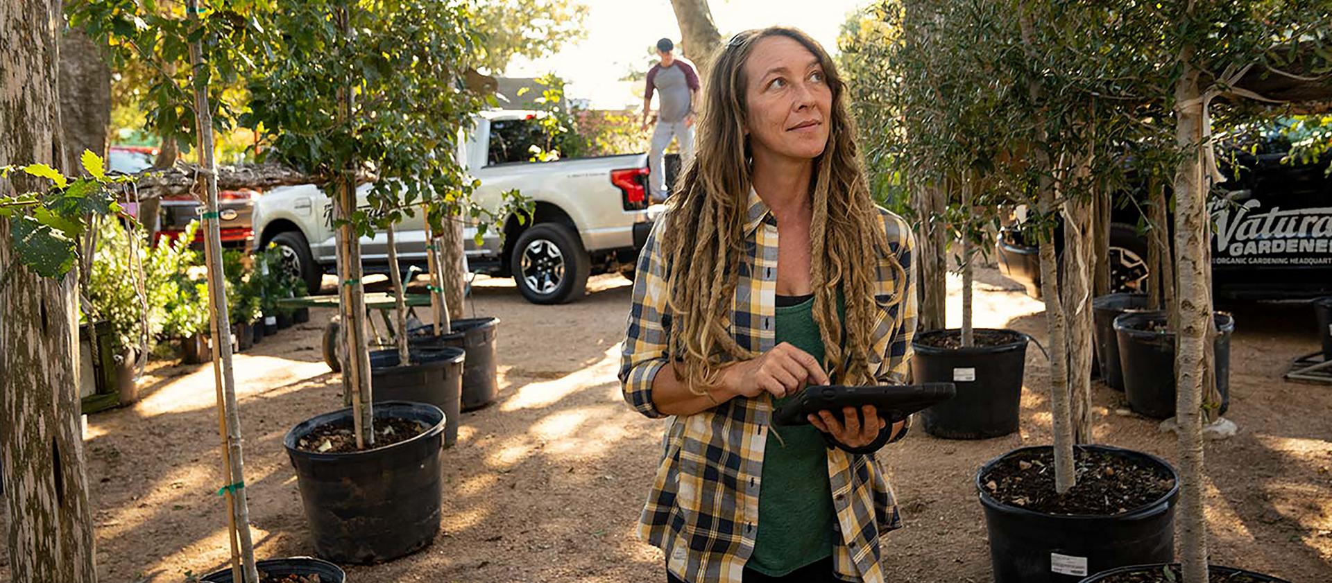 Woman holding tablet at garden nursery