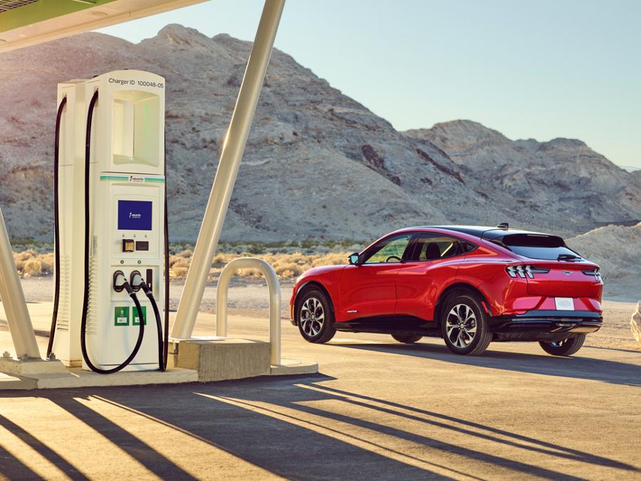 A 2023 Ford Mustang Mach-E parked next to a BlueOval™ Charge Network charging station