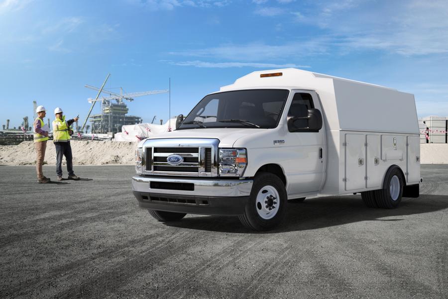 Deux travailleurs de la construction près d’un fourgon tronqué Ford série E 2025 avec carrosserie modifiée d’entrepreneur