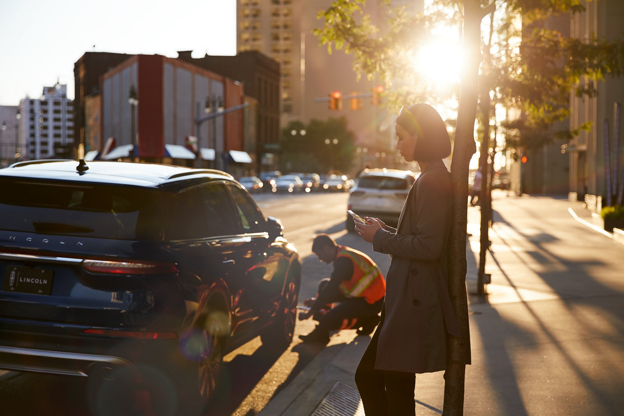 A woman waits for Lincoln Roadside assistance that is looking at her vehicle