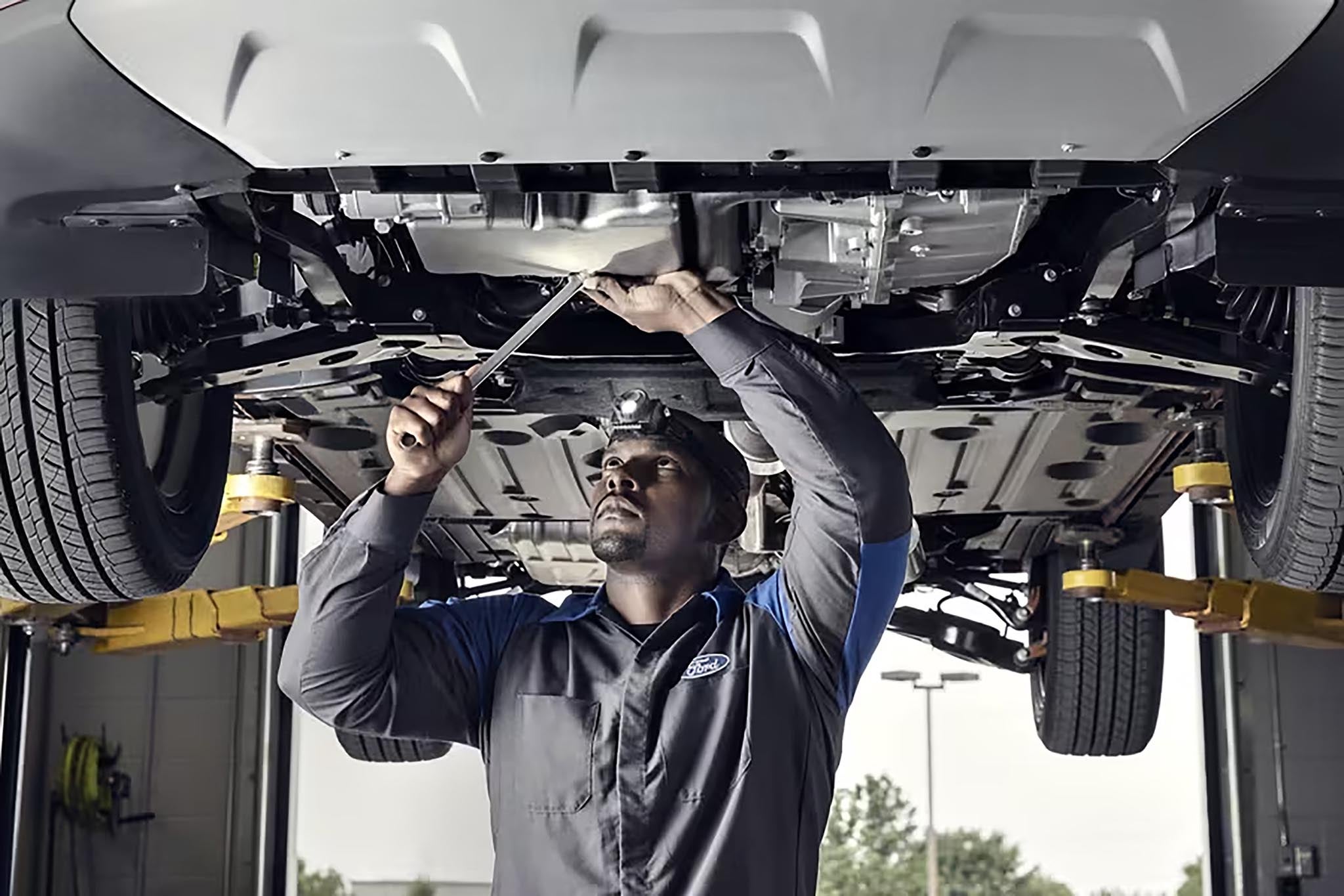 Ford factory-trained technician inspecting the underside of a vehicle