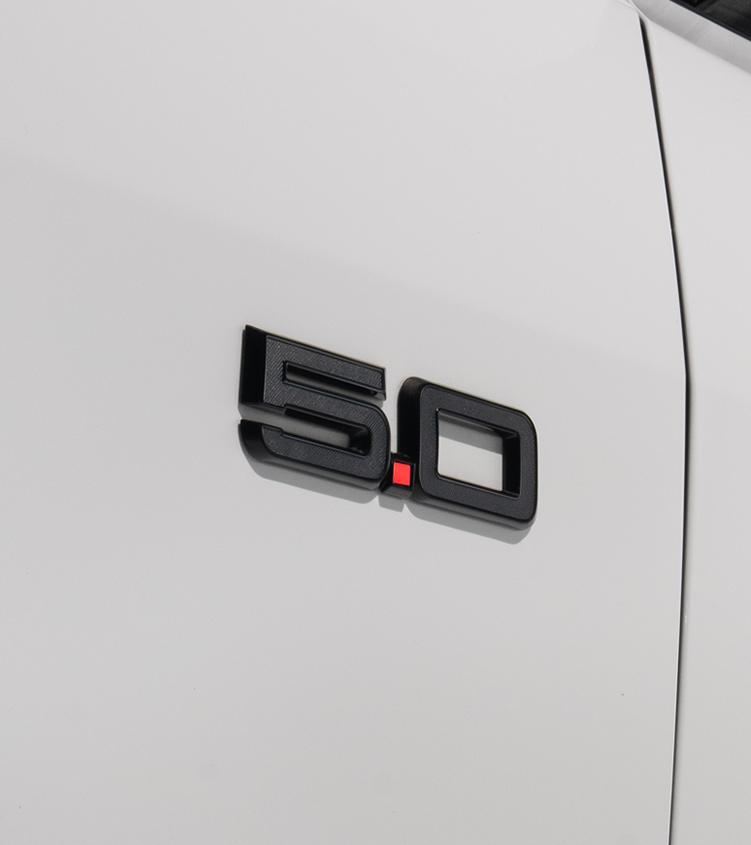 Close-up of the black 5.0 fender badge on the white Mustang