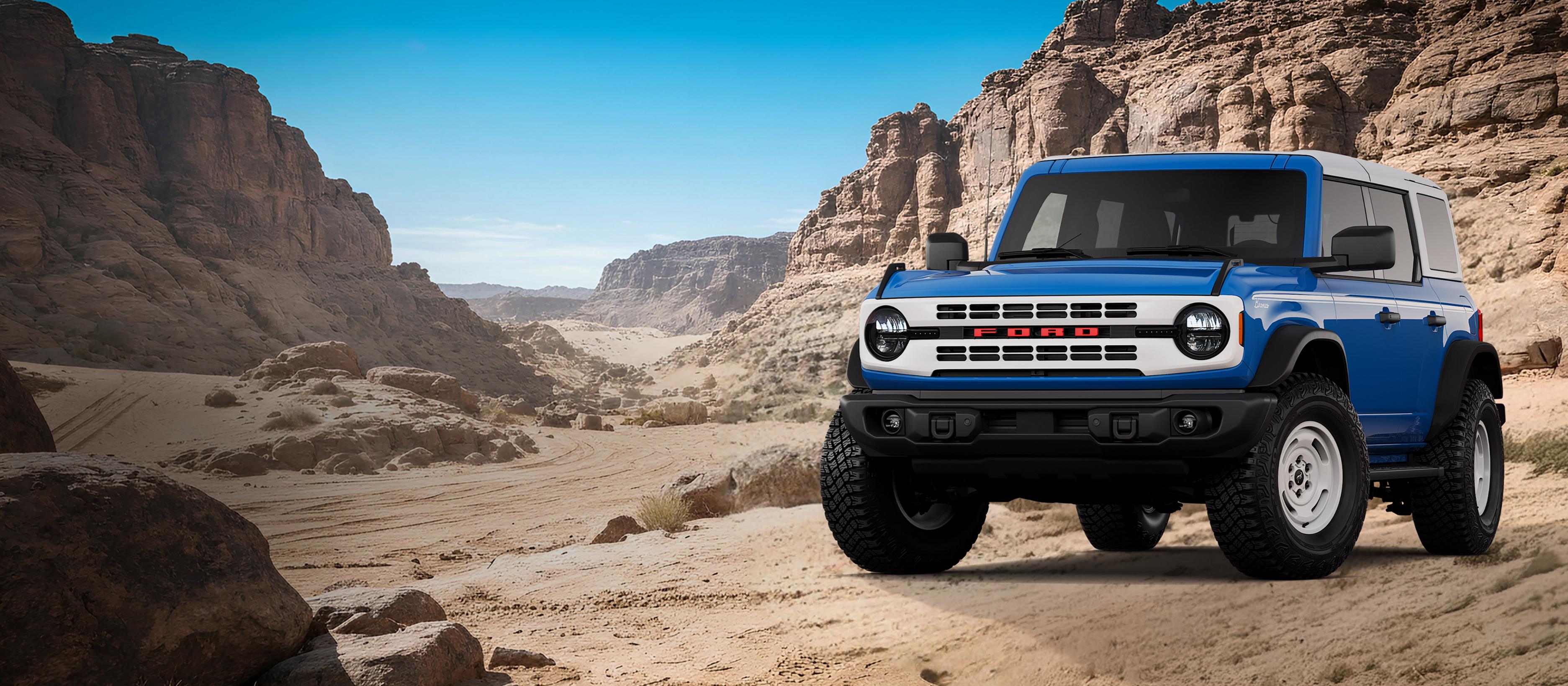 A 2026 Ford Bronco® Heritage Edition model shown in Ruby Red parked on a rocky expanse