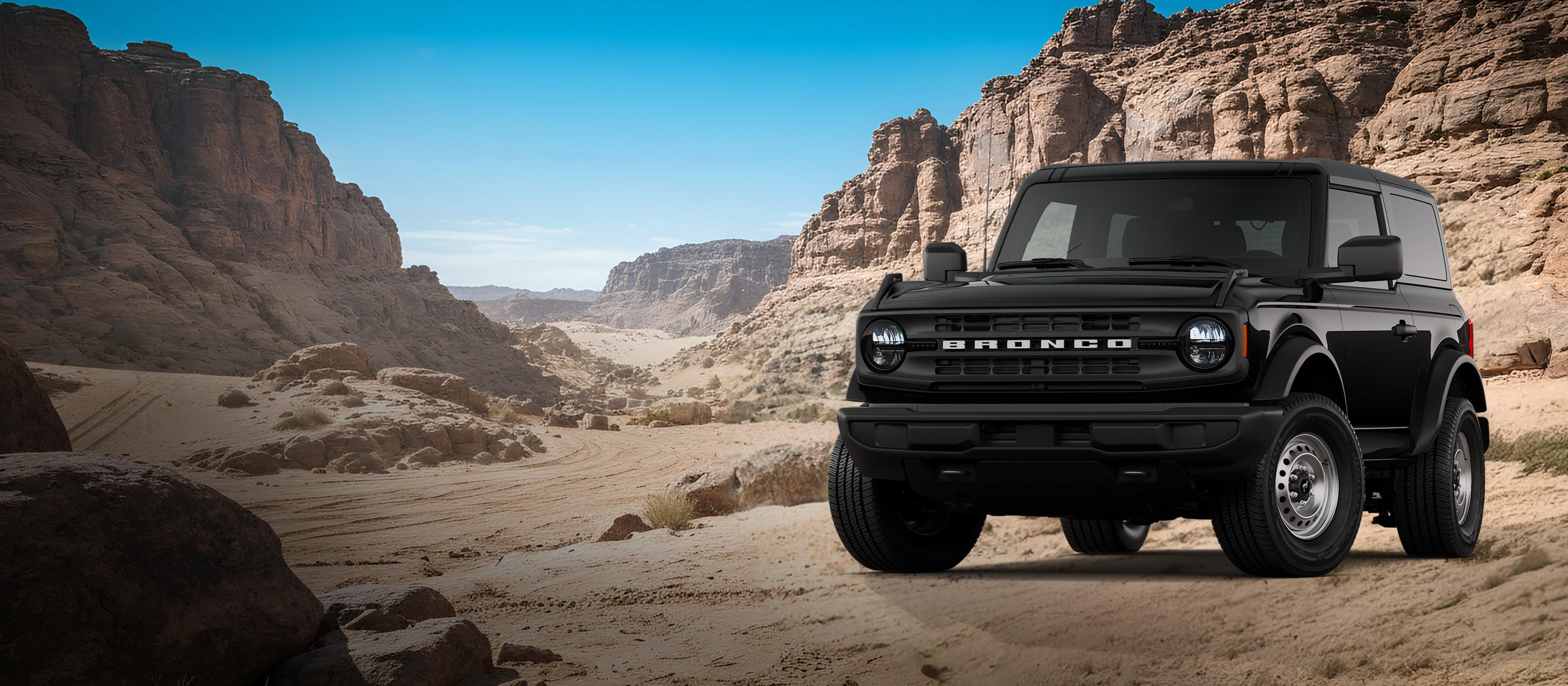 A 2026 Ford Bronco® Base model shown in Shadow Black parked on a rocky expanse