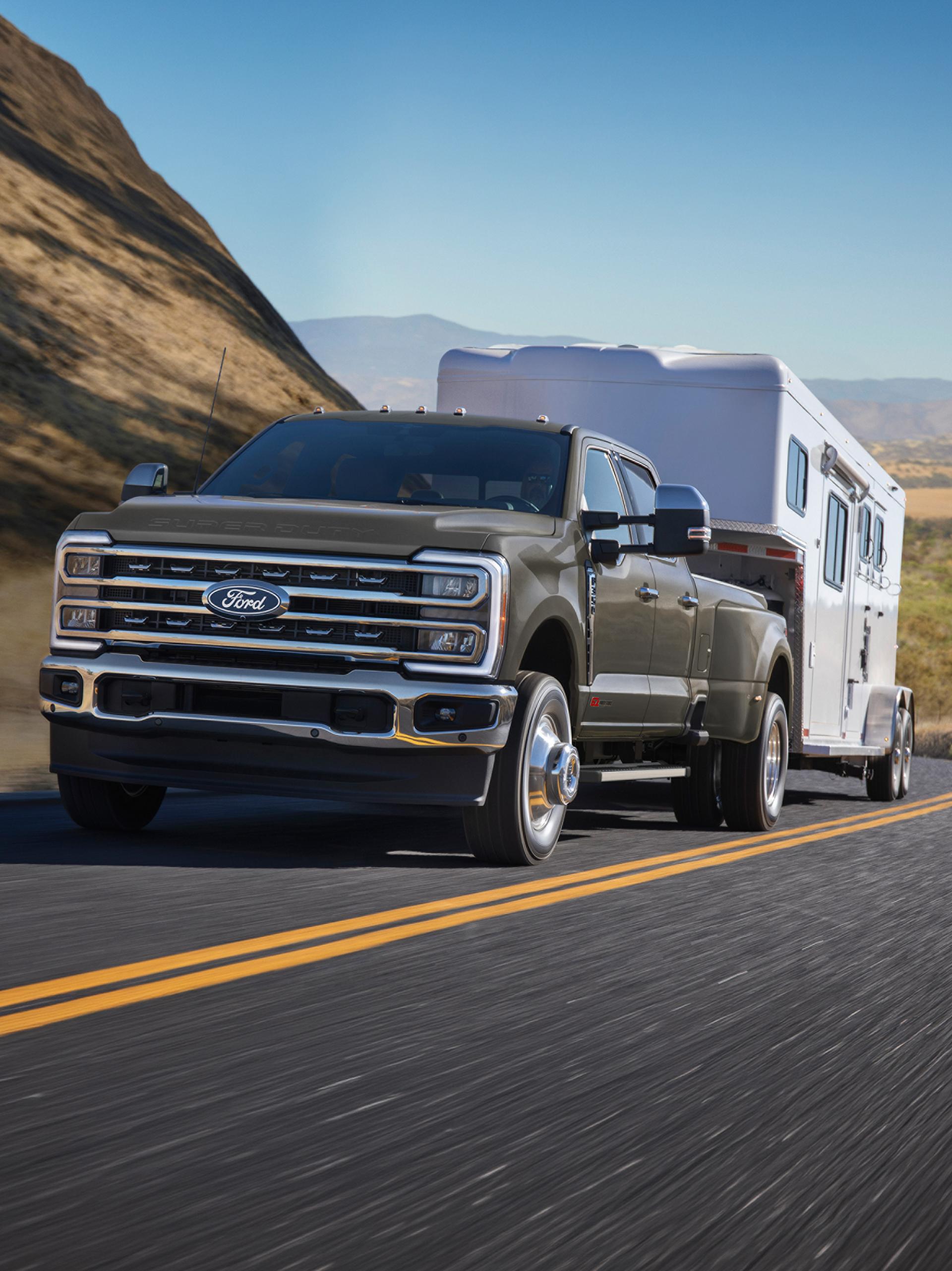 2027 Ford Super Duty® F-350® Lariat® pickup pulling a large camper on a mountain road