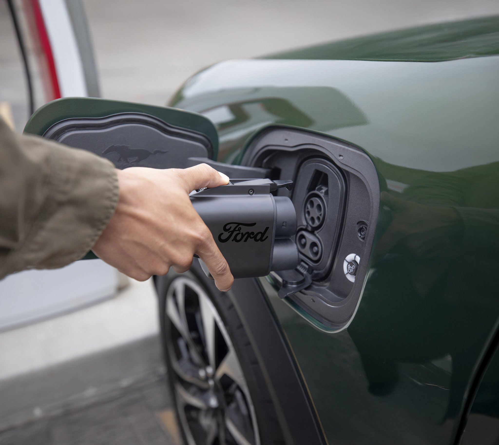Person connecting a Mustang Mach-E to a charge station.