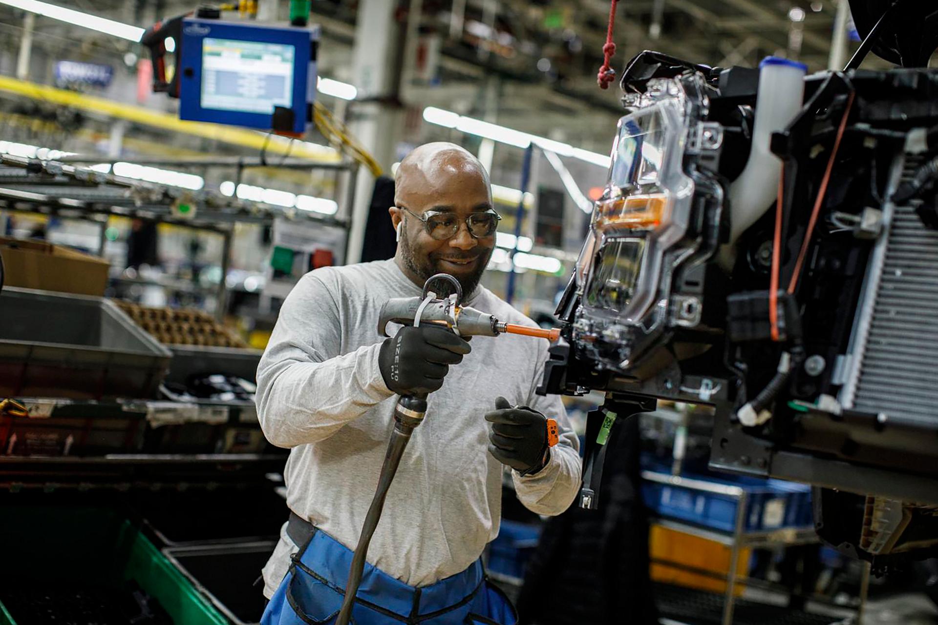 A Ford team member works on an assembly line