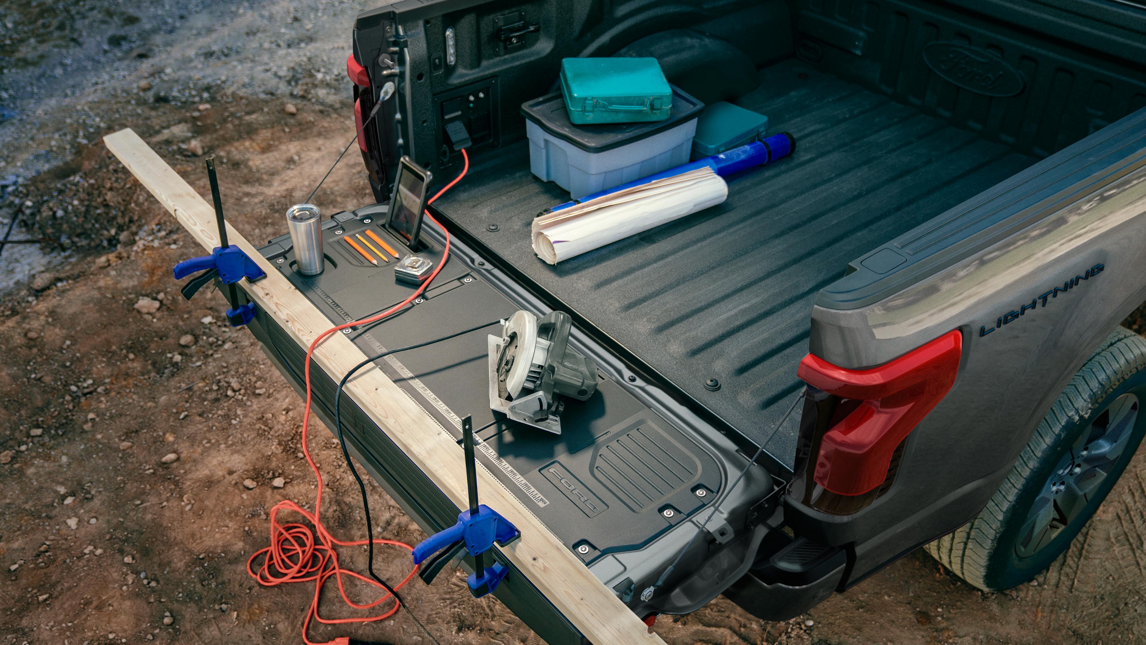 The cargo bed of a 2025 Ford F-150® Lightning® pickup with the tailgate down, showing the Tailgate Work Surface