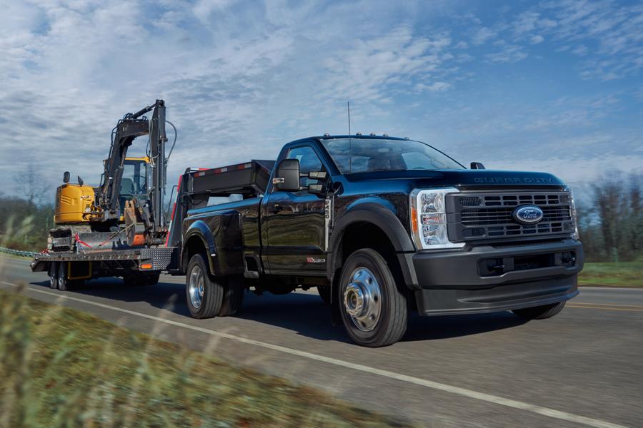 Camionnette Ford Super Duty® F-450® XL 2025 en noir agate tirant une rétrocaveuse sur une remorque