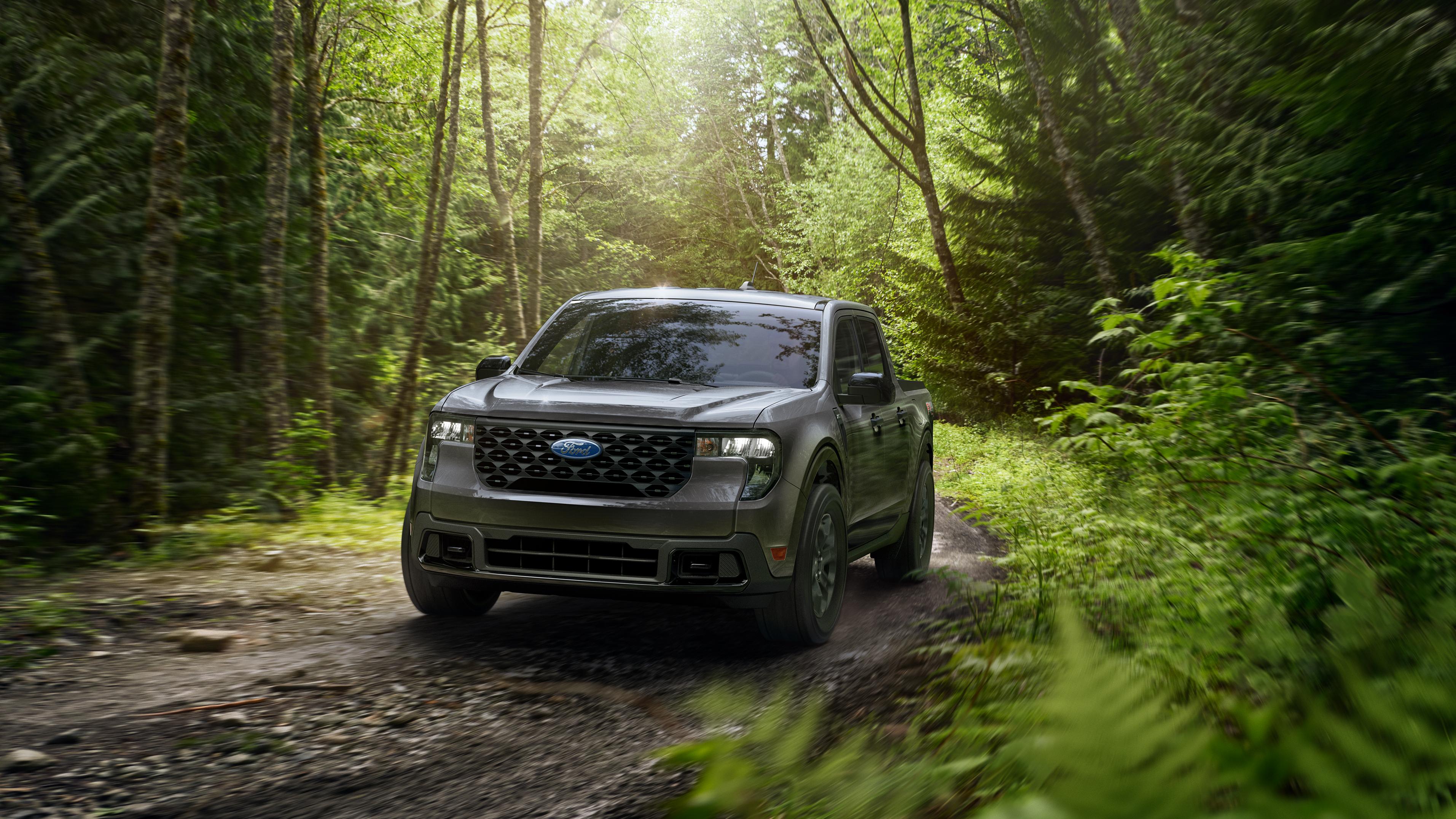 A 2026 Ford Maverick® XLT pickup with FX4® Off-Road Package driving on a muddy forest trail