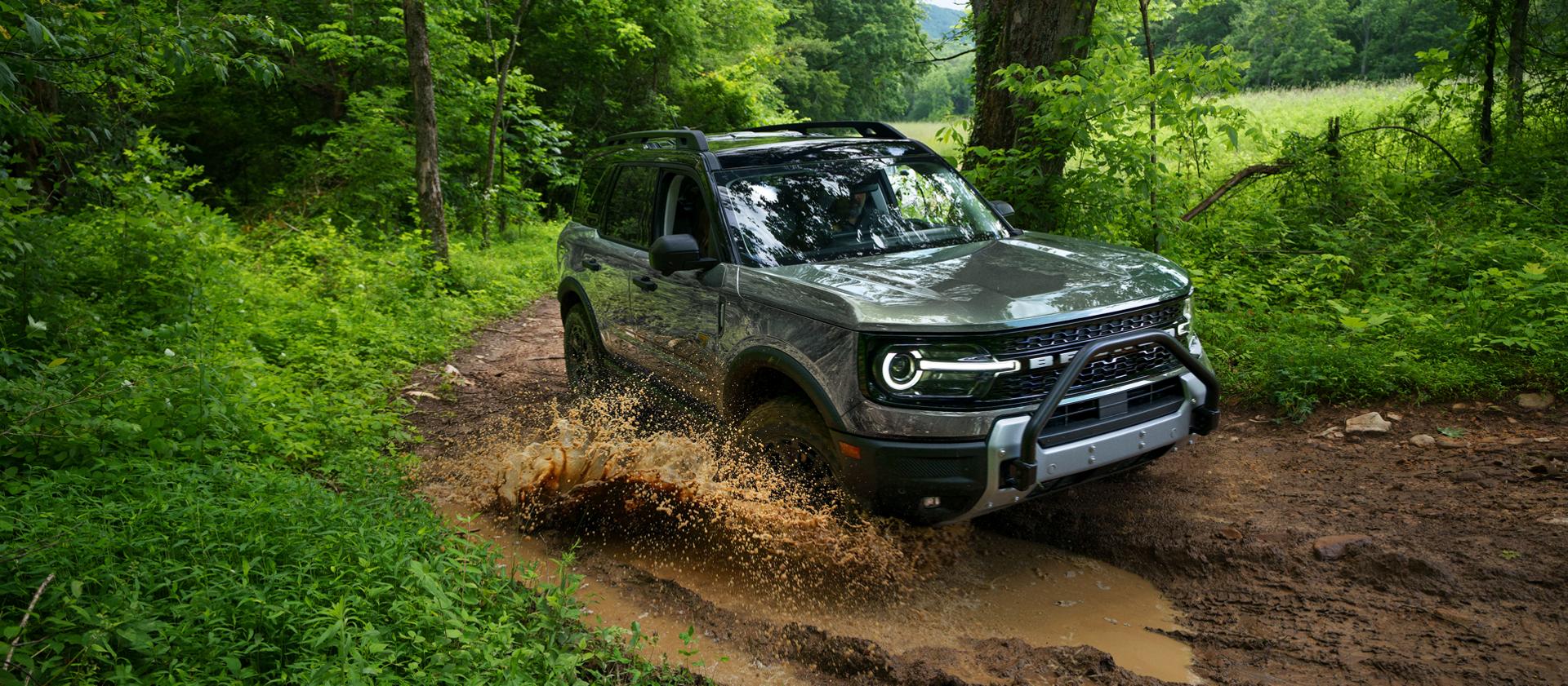 A 2026 Ford Bronco Sport® SUV being driven on a dirt trail in the woods