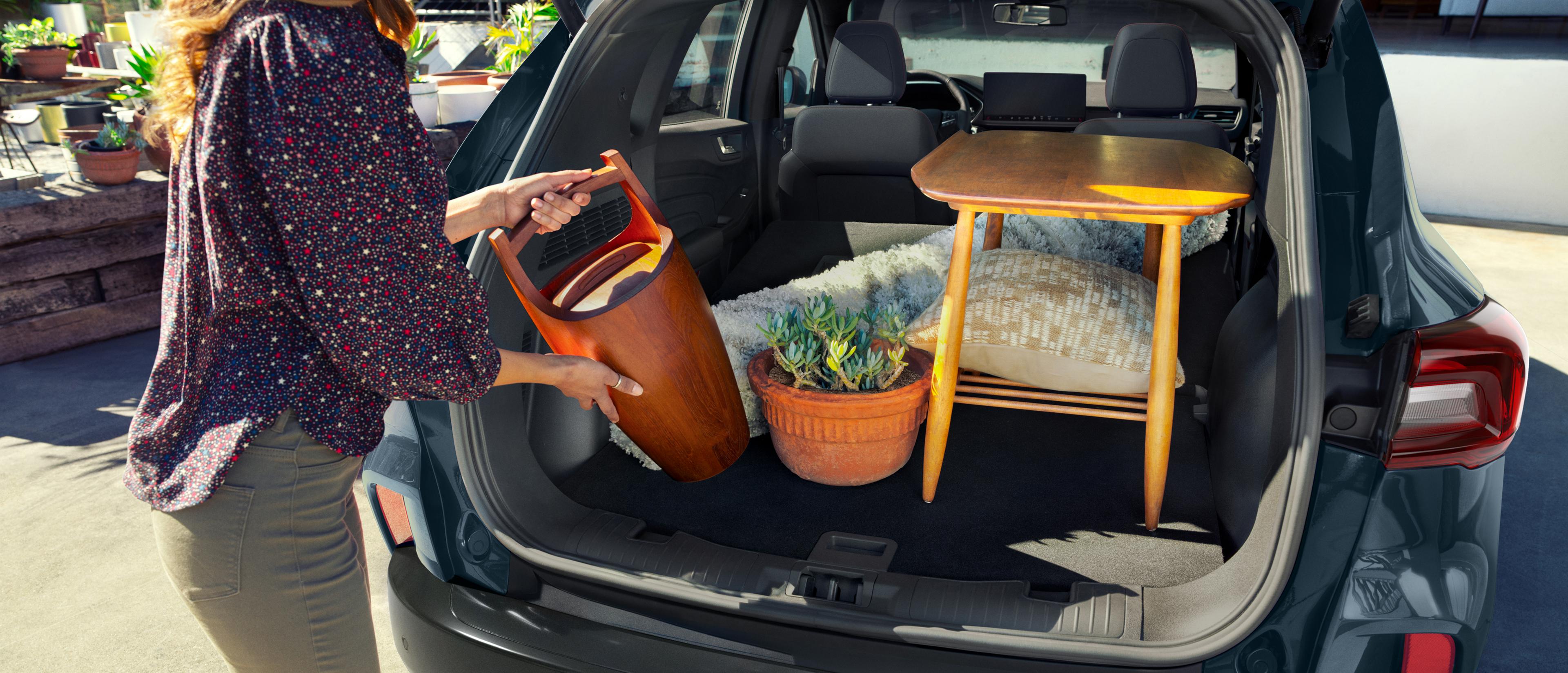 Woman loading items into the cargo area of a 2026 Ford Escape® SUV