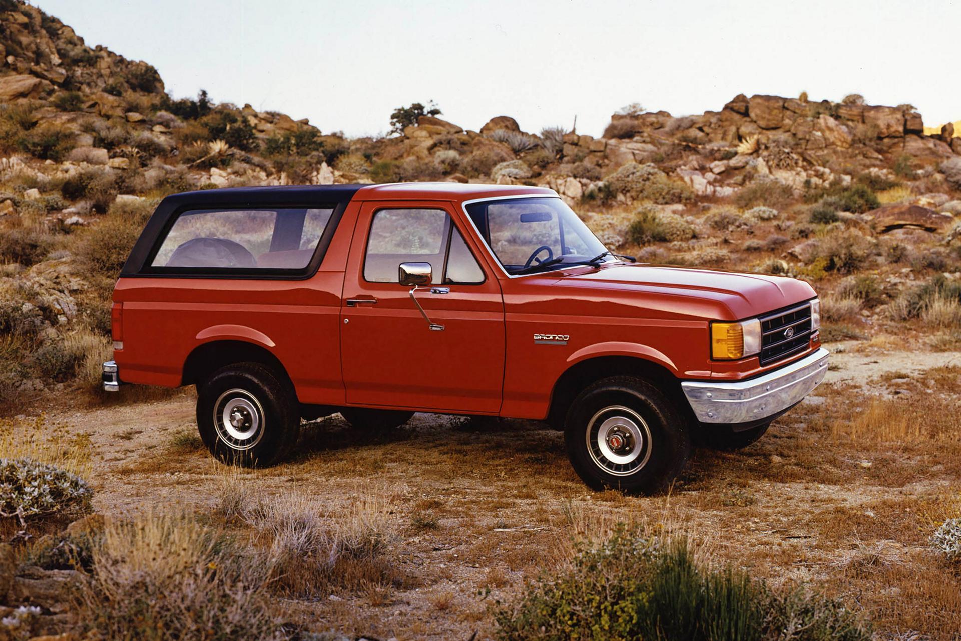 A vintage 1987 red Ford Bronco® model parked amidst a desert landscape