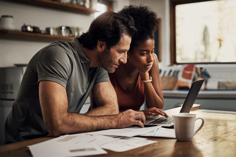 Un couple regardant un ordinateur portable dans la cuisine
