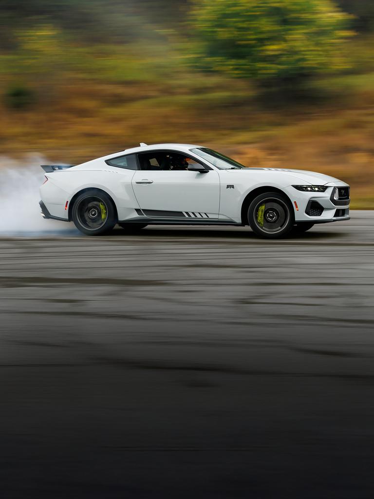 2026 Mustang® RTR® fastback with a driver performing burnouts on a closed course