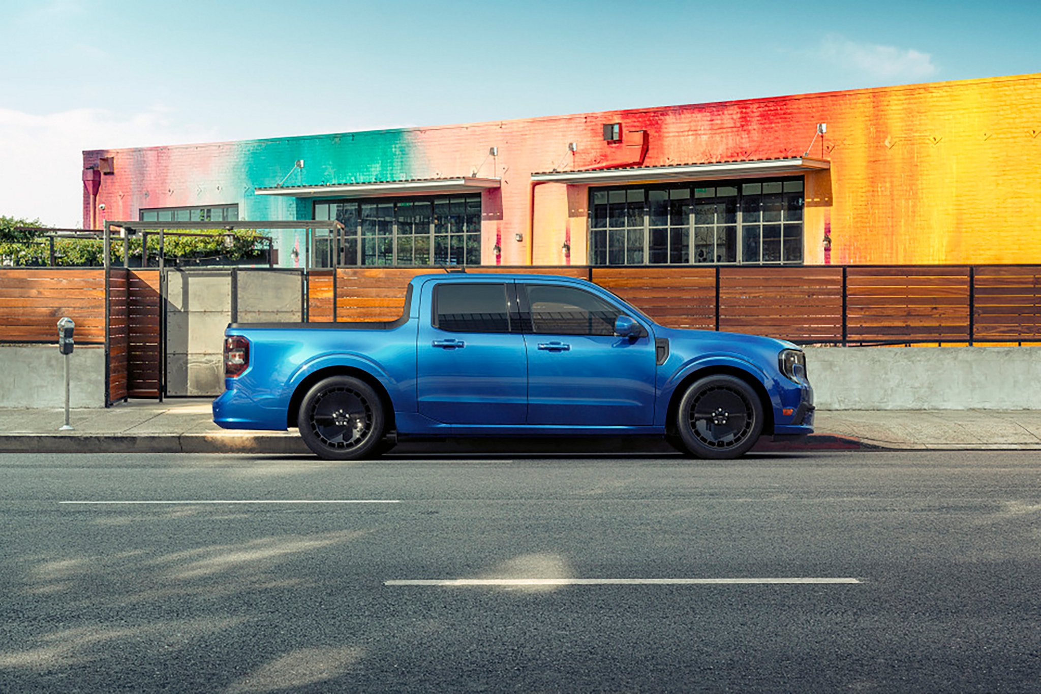 A blue 2026 Ford Maverick® Lobo™ pickup parked in front of a colorful restaurant