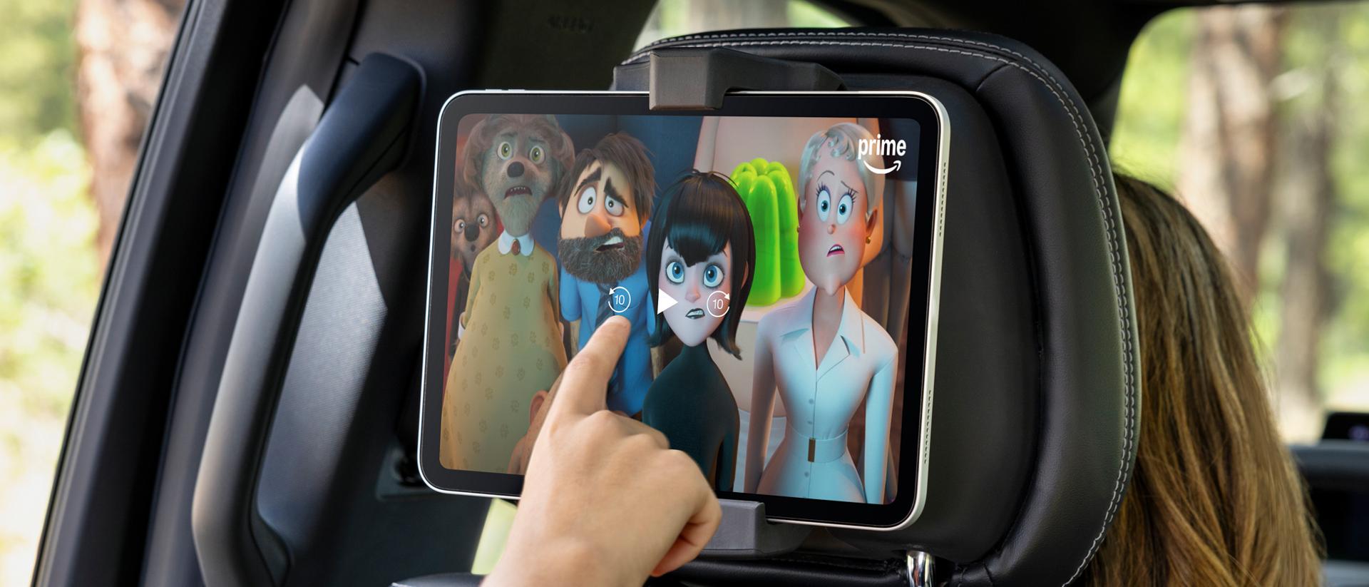 Passenger using a tablet in the available second-row digital device holder in a 2027 Ford Expedition® SUV