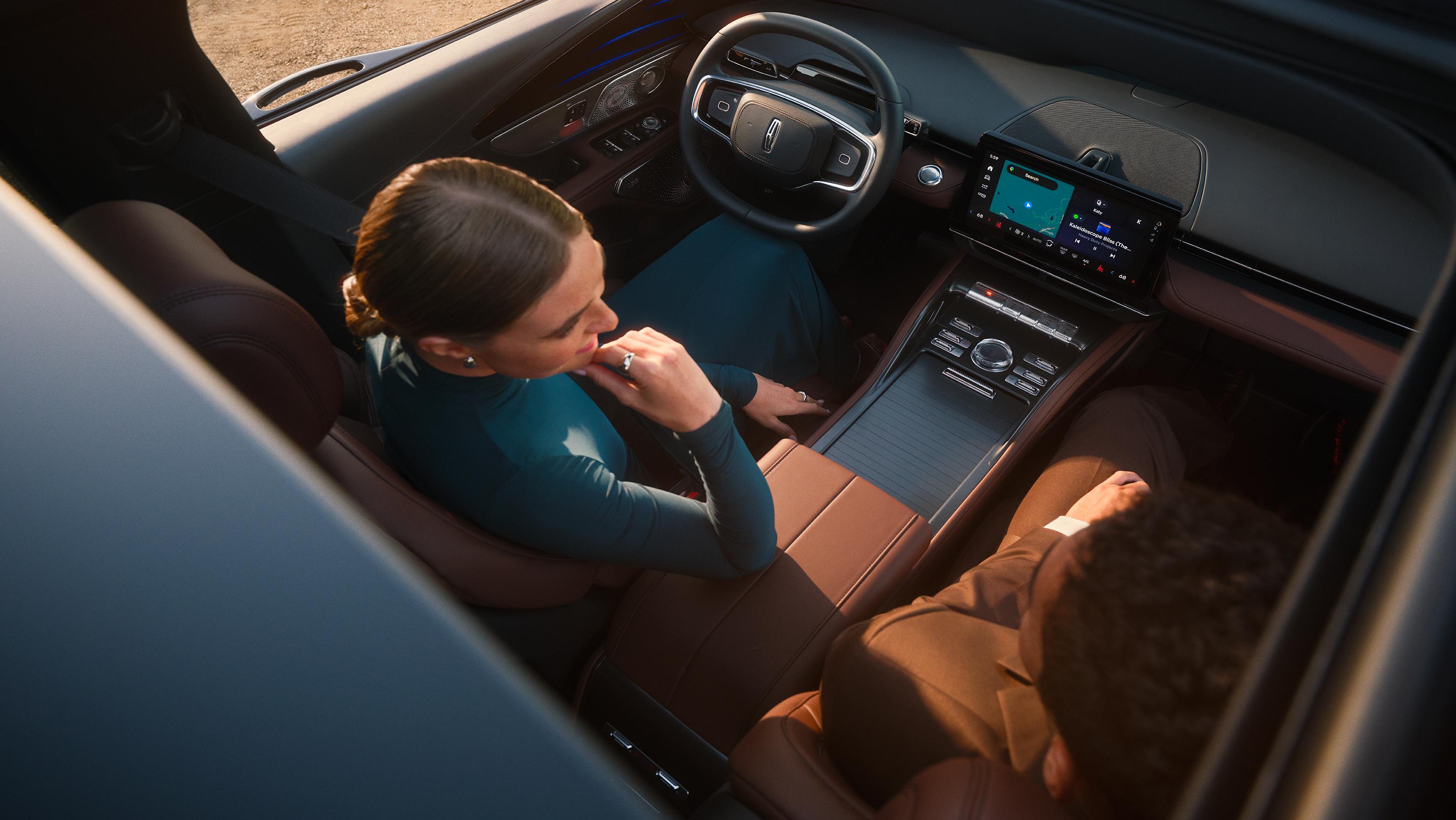 A woman in the driver seat of a 2026 Lincoln Nautilus® SUV speaks to a passenger