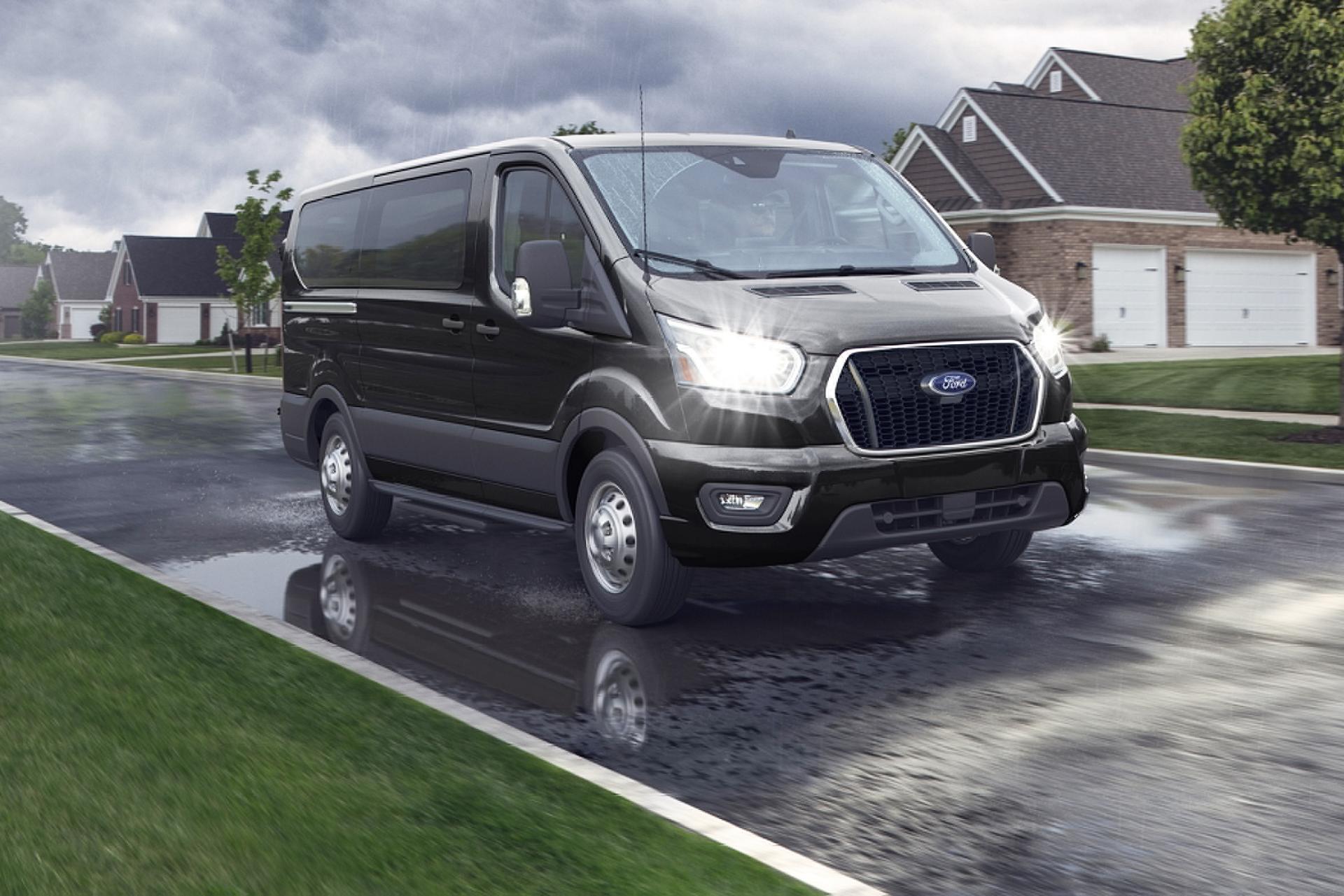 Black 2025 Ford Transit® van being driven through a neighborhood