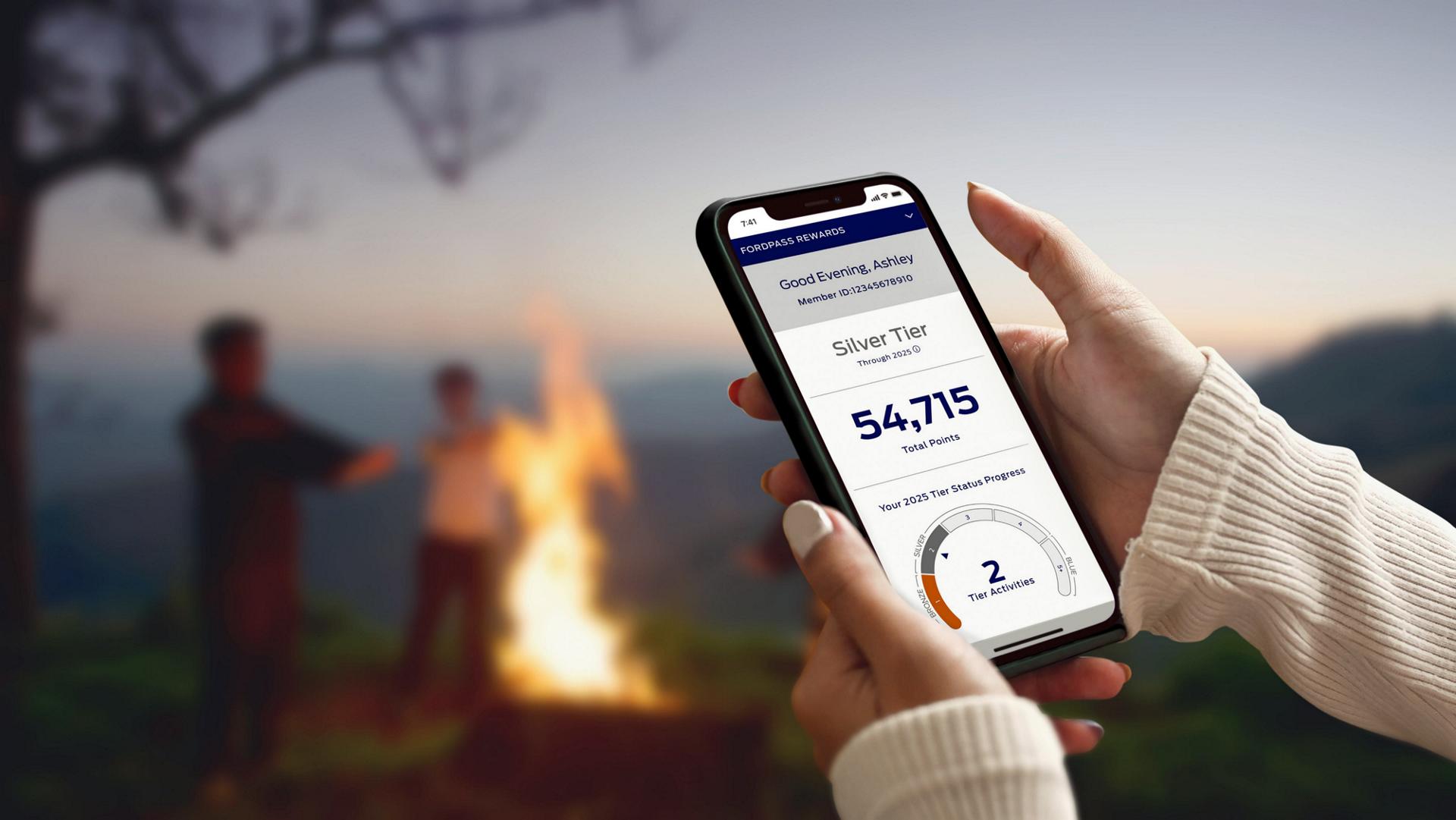 Hands are holding a smartphone and interacting with the FordPass® app