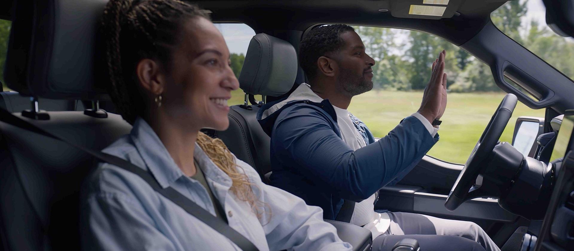 A close-up of two people inside a 2025 Ford F-150® Lightning® engaged with the Ford BlueCruise feature
