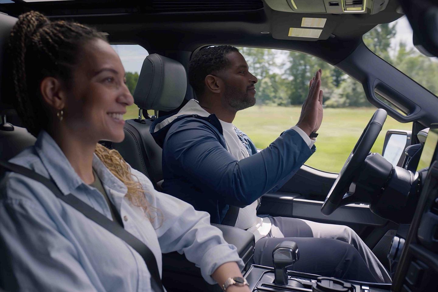 A close-up of two people inside a 2025 Ford F-150® Lightning® engaged with the Ford BlueCruise feature