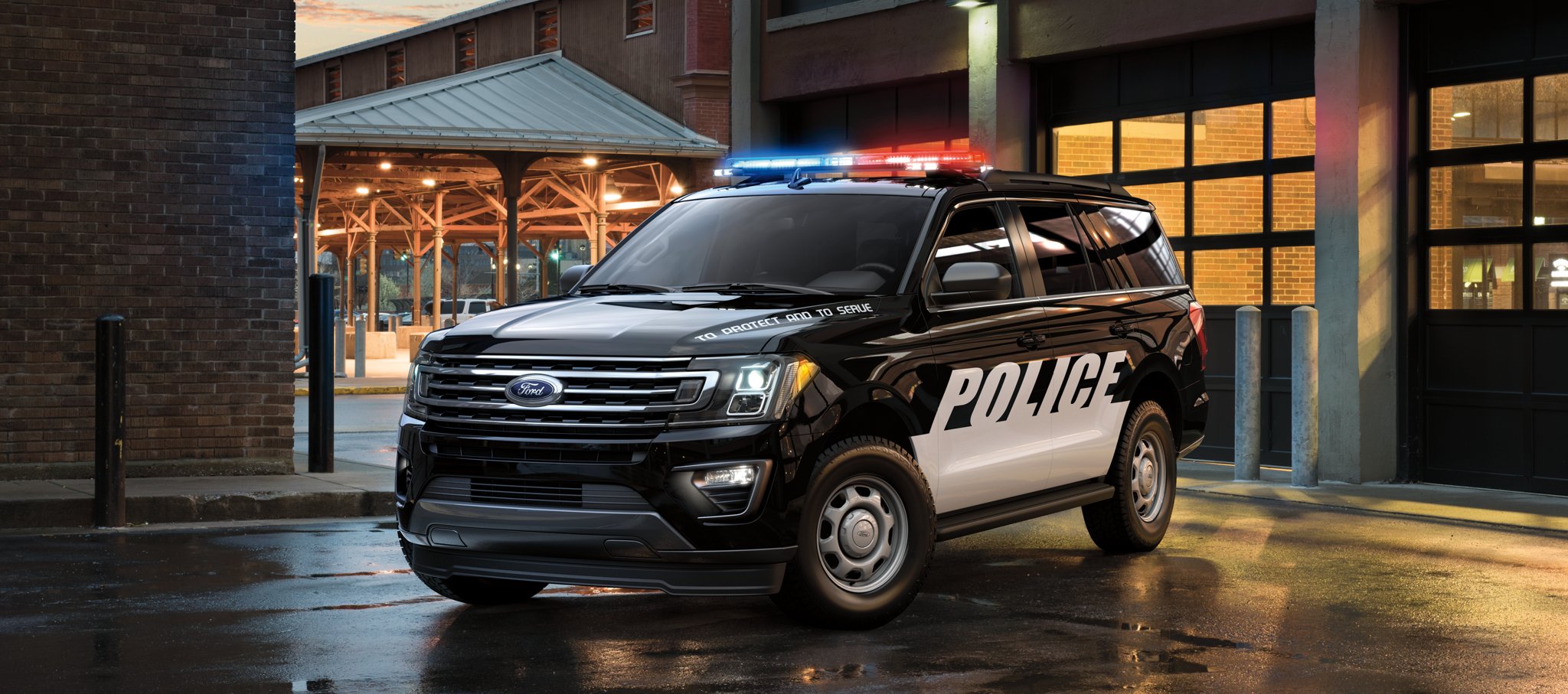 The twenty twenty one ford expedition special service vehicle in front of a city garage