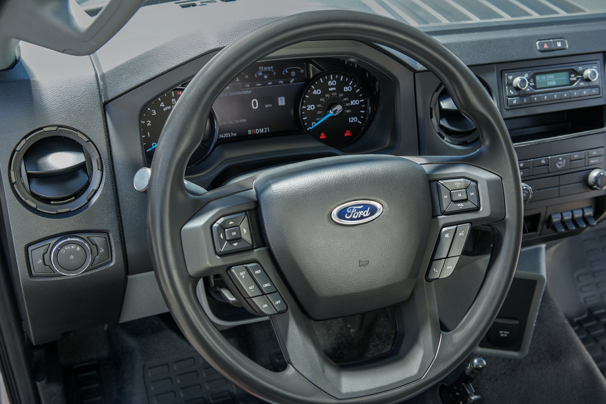 Gros plan sur le tableau de bord et le volant inclinable et télescopique du Ford F-750 2025 avec commandes audio intégrées