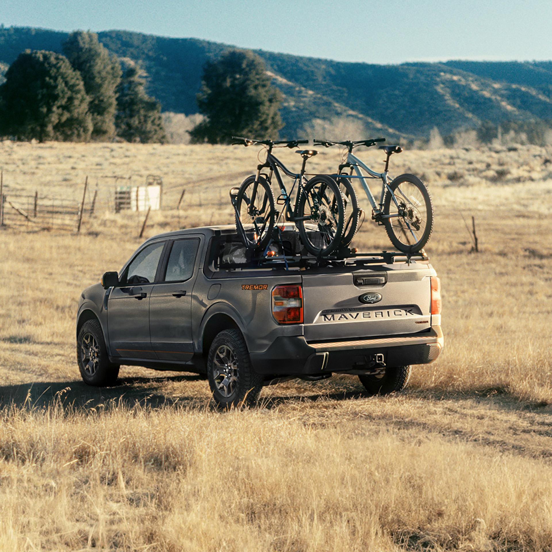 2026 Ford Maverick® Tremor® model being driven on a grassy field with bikes mounted in the bed