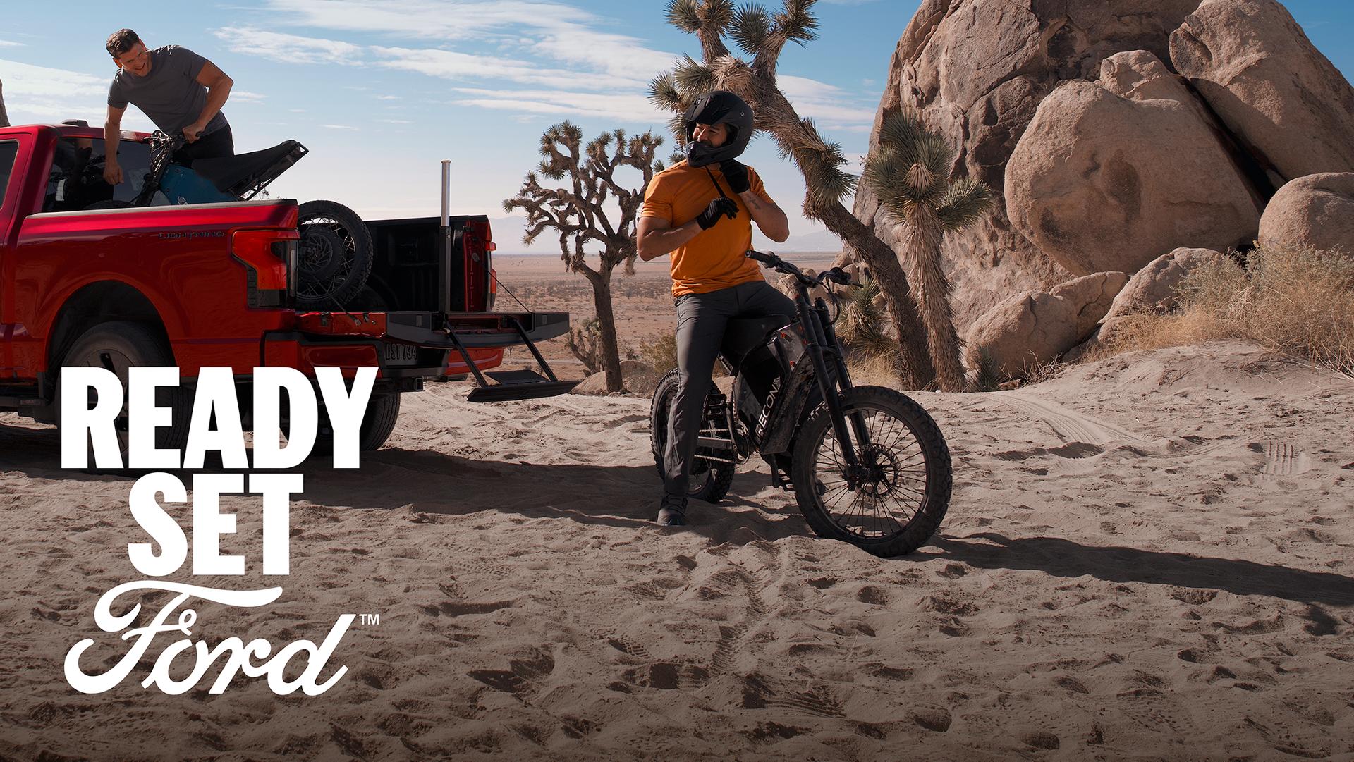 Two people unloading mountain bikes from the bed of a 2025 Ford F-150® Lightning®