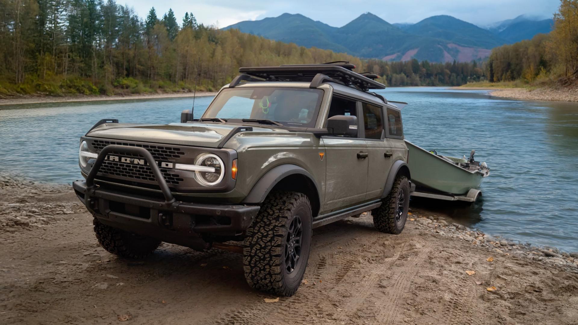 A 2026 Ford Bronco® SUV pulling a boat on a trailer out of a lake