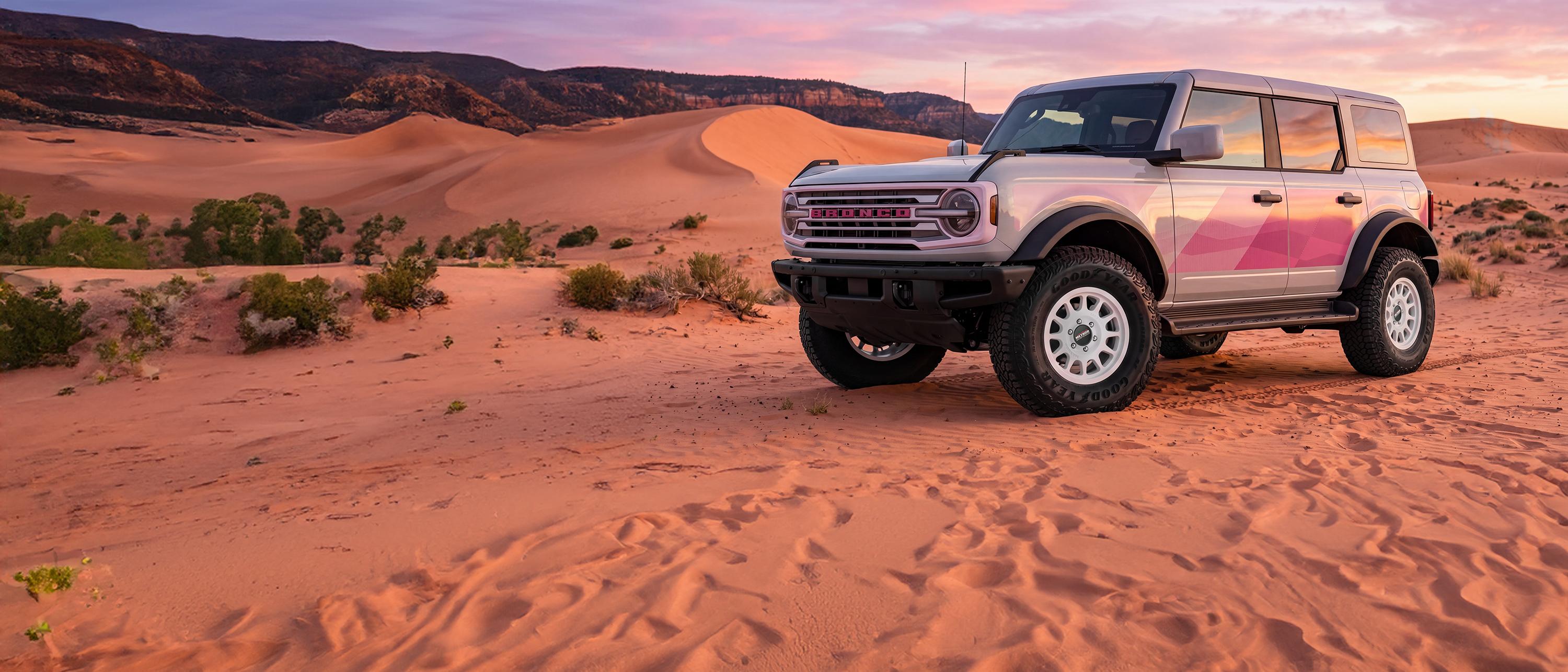 Ford Bronco on sand dunes at sunset