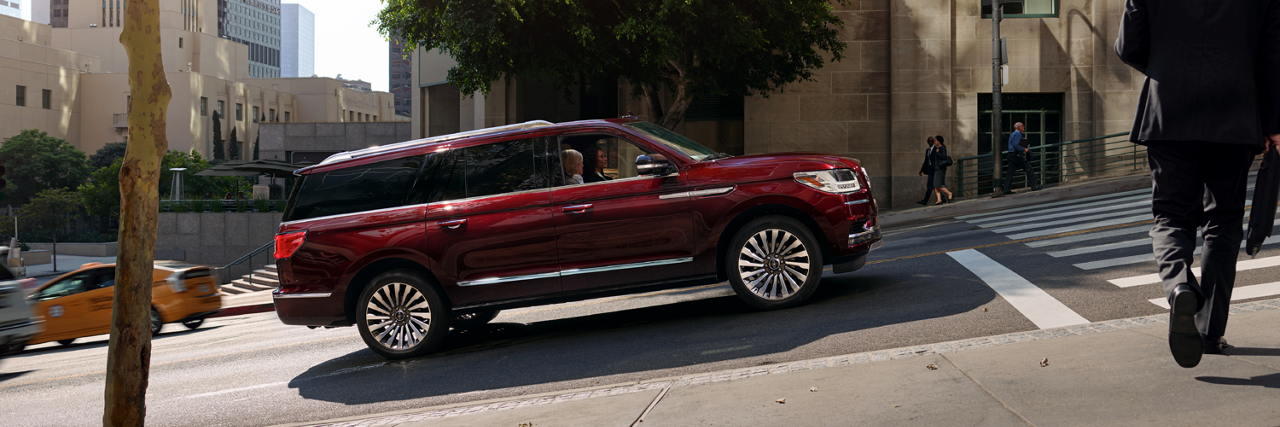 a Lincoln vehicle stopped on a street with a steep incline is shown here