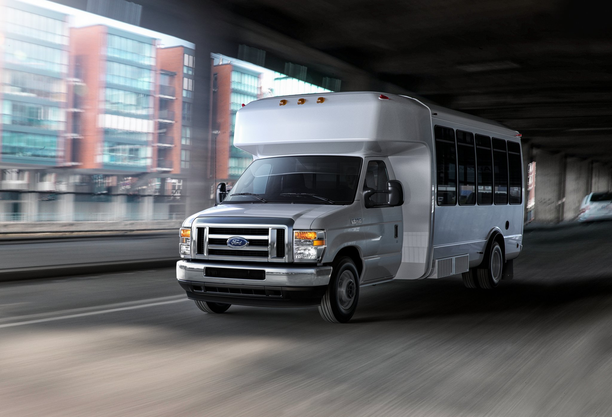 Fourgon tronqué Ford série E 2025 à roues arrière jumelées avec modification pour bus-navette circulant sous un pont