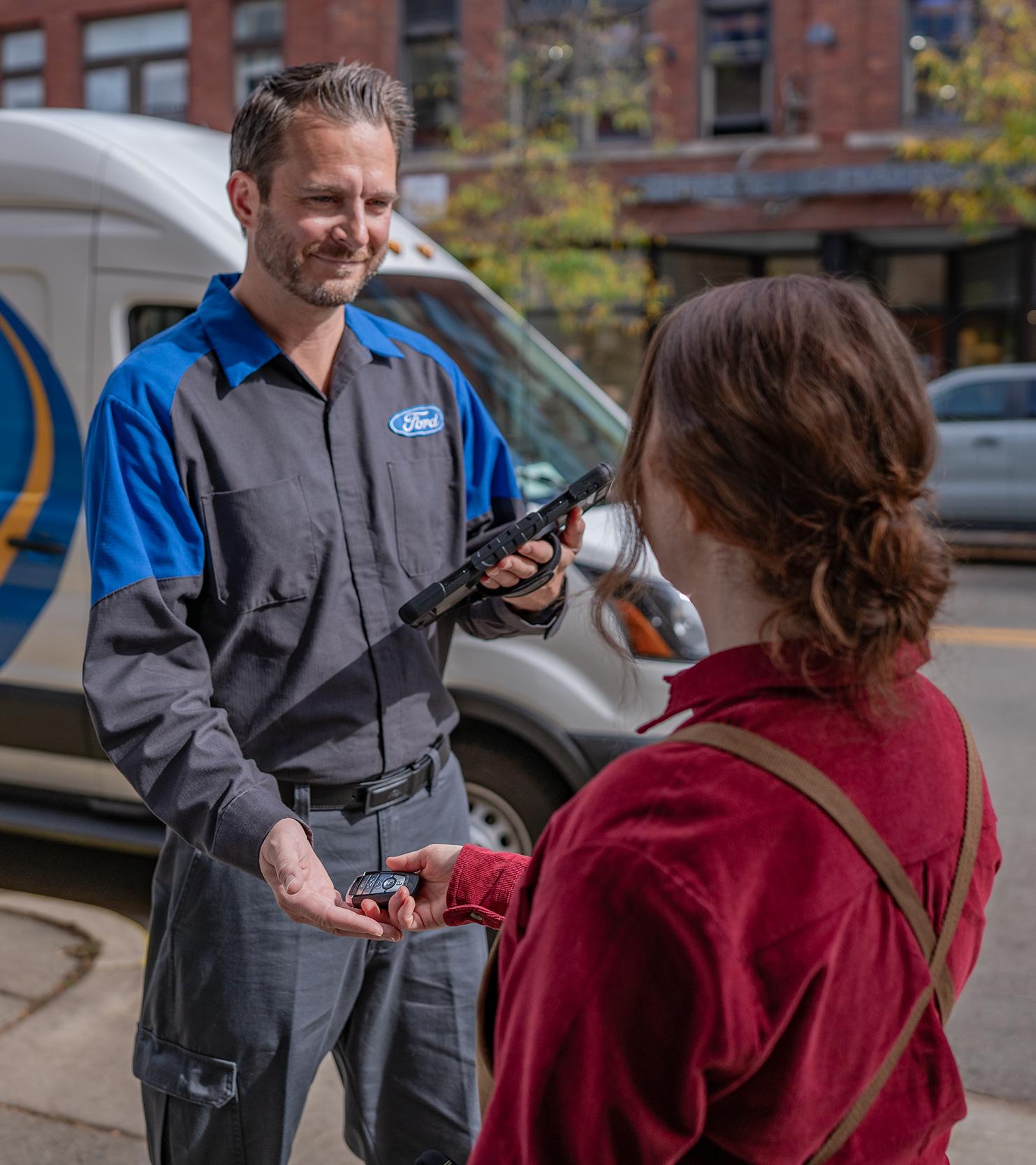 A Ford owner hands their keys to a Ford Mobile Service technician