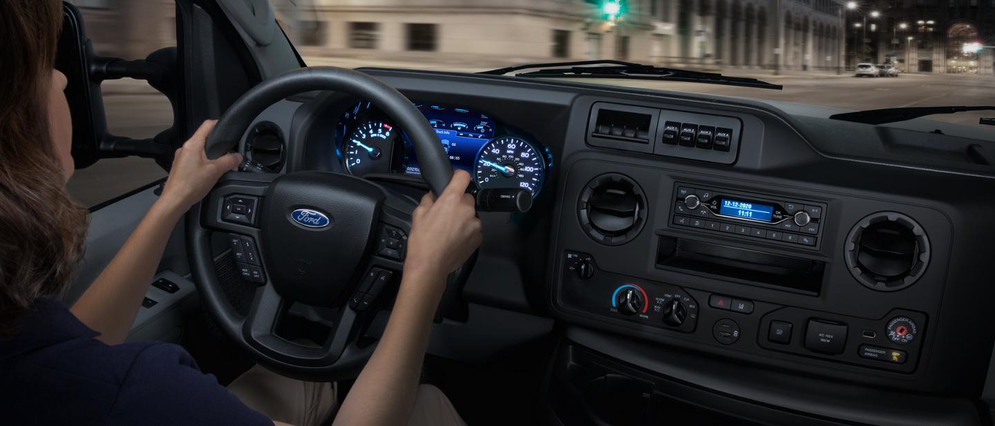 A woman driving a 2026 Ford E-Series Cutaway