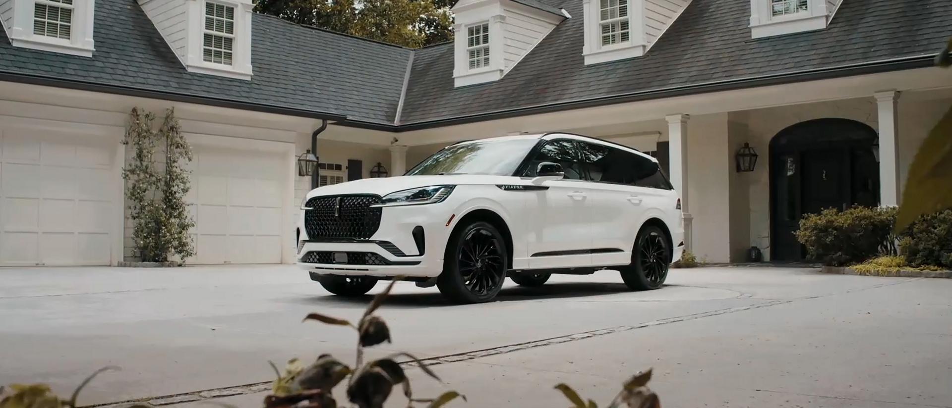 A 2026 Lincoln Aviator® is parked in the driveway of a luxury home